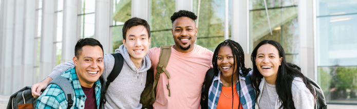 Five adolescents standing in line in front of a line of windows in a public space