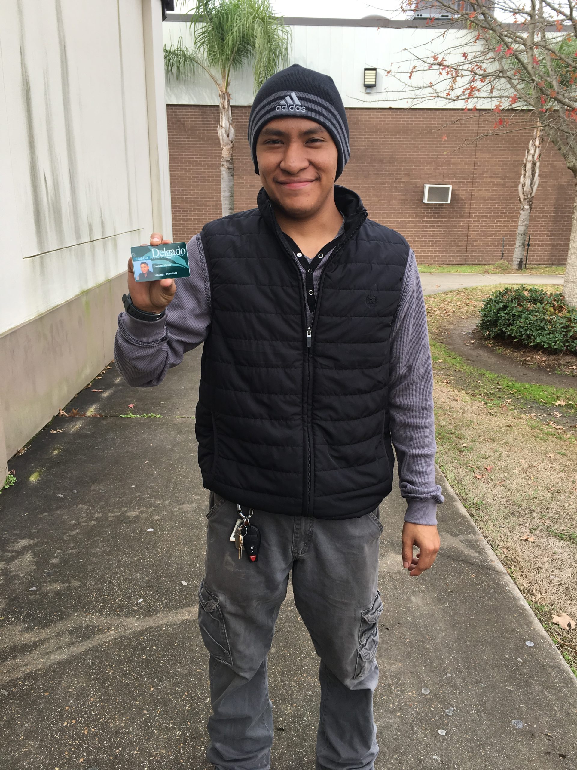 Victor Castillo smiling with his student ID badge for Delgado Community College.