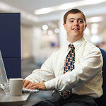 White man who appears to have Down syndrome working at computer