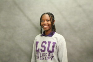 Black-haired woman in gray LSU Physical Therapy sweatshirt covering purple polo shirt whose collar is showing